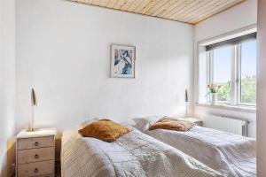a bedroom with two beds and a window at 138-Ringkobing-Sondervig-Klitvej-3 in Søndervig