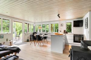 a kitchen and living room with a table and chairs at 1134-Ringkobing-Egernvej-12 in Nørby