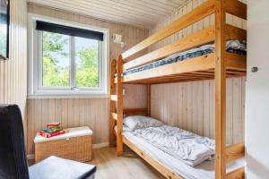 a bedroom with two bunk beds and a window at 1134-Ringkobing-Egernvej-12 in Nørby