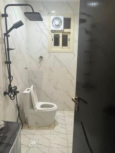 a bathroom with a toilet with a window and a camera at قنوف-شقة فندقية خاصة ذ in Abha +2 photos