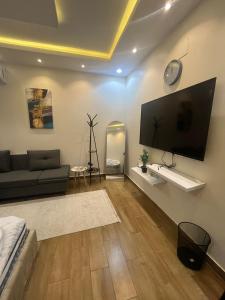 a living room with a couch and a flat screen tv at قنوف-شقة فندقية خاصة ذ in Abha