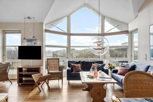 a living room with a blue couch and a tv at 1177-Ringkobing-Anders-Juhls-Vej-10 in Søndervig