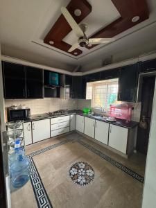 a kitchen with white cabinets and a ceiling at 6-BedRoom house in Bahria in Lahore +9 photos