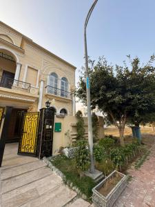 a house with a yellow door and a street light at 6-BedRoom house in Bahria in Lahore