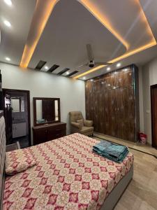a bedroom with a large bed and a chair in it at 6-BedRoom house in Bahria in Lahore