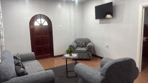 a living room with couches and chairs and a television at Peaceful Paraiso in New Amsterdam