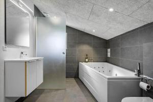 a bathroom with a tub and a toilet and a sink at 1102-Ringkobing-Gransangervej-14 in Nørby +46 photos