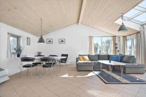a living room with a couch and a table and chairs at 2202-Ringkobing-Lyngvejen-73 in Klegod