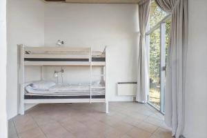 a room with two bunk beds and a window at 2202-Ringkobing-Lyngvejen-73 in Klegod