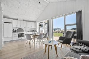 a kitchen and living room with a table and chairs at 1194-Ringkobing-Havstien-203 in Søndervig