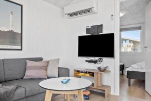 a living room with a couch and a table at 1194-Ringkobing-Havstien-203 in Søndervig