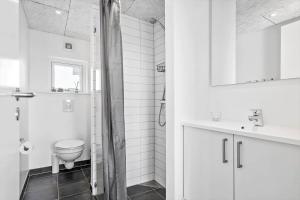 a white bathroom with a toilet and a sink at 1194-Ringkobing-Havstien-203 in Søndervig +38 photos