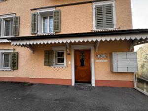 a building with a brown door and windows at HausHarder Rooms in Gommiswald