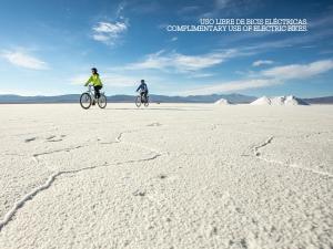 two people riding bikes in the middle of the desert at Salinas Grandes Jujuy - Pristine Luxury Camp in Salinas Grandes