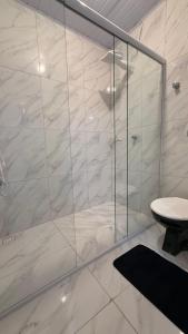 a bathroom with a glass shower with a toilet at Flat a 3 minutos do centro de Chapecó in Chapecó