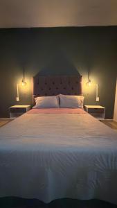 a bedroom with a large bed with two lamps on it at Cerro Escondido in Chiapa de Corzo
