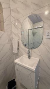a white bathroom with a sink and a mirror at Flat a 3 minutos do centro de Chapecó in Chapecó