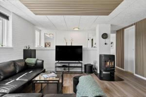 a living room with a couch and a fireplace at 2248-Ringkobing-Vestklitvej-16-A in Klegod