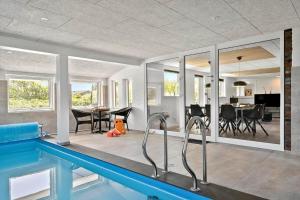 a house with a swimming pool and a dining room at 2248-Ringkobing-Vestklitvej-16-A in Klegod