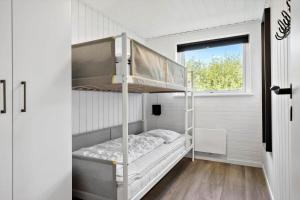 a bunk bed in a small room with a window at 2248-Ringkobing-Vestklitvej-16-A in Klegod +33 photos