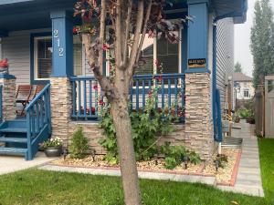 a house with a tree in the front yard at Blue Kuti B&B in Edmonton