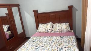 a bed with a wooden headboard next to a mirror at Peaceful Paraiso in New Amsterdam