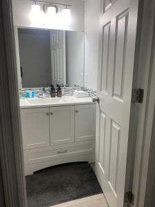 a white bathroom with a sink and a mirror at Blue Kuti B&B in Edmonton +16 photos
