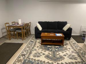 a living room with a black couch and a table at Blue Kuti B&B in Edmonton