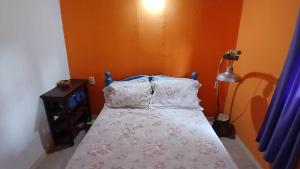 a small bedroom with a bed with white sheets and pillows at Cabaña Tupa mba'e, En el Ibera in San Miguel