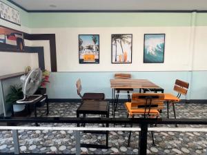 a room with a table and chairs and pictures on the wall at Suanpai Resort Sattahip in Sattahip