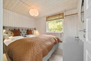 a bedroom with a large bed and a window at FY325-Munkebo-Kamsbjerghuse-1-b in Munkebo