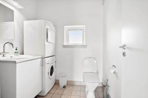 a white kitchen with a sink and a washer and dryer at FY293-Faaborg-Mosegarden-42 in Faaborg +14 photos