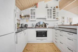 a white kitchen with white cabinets and a wooden floor at FY289-Faaborg-Avernakovej-22 in Faaborg