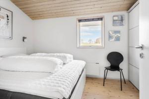 a bedroom with a bed and a chair in it at FY289-Faaborg-Avernakovej-22 in Faaborg