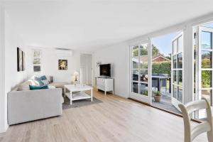 a white living room with a couch and a tv at FY318-Nyborg-Sommerbyen-23 in Nyborg