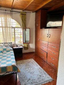 a bedroom with a bed and a dresser and a window at Finca Dinastia in Fusagasuga