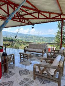 a patio with couches and tables and a view at Finca Dinastia in Fusagasuga