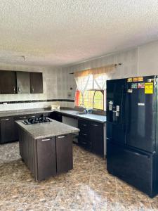 a kitchen with a black refrigerator and a stove at Finca Dinastia in Fusagasuga