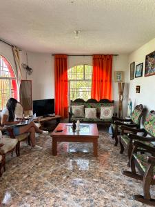 a woman sitting on a couch in a living room at Finca Dinastia in Fusagasuga