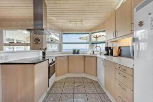 a large kitchen with wooden cabinets and a sink at FY261-Ebberup-Hasselvaenget-22 in Ebberup