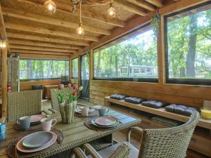 a dining room with a table and chairs and windows at t Heische hofje in Zeeland
