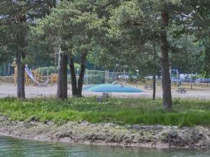 a park with a playground with a slide and trees at t Heische hofje in Zeeland