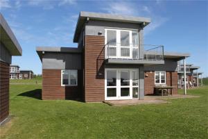 a house with a balcony on a grass field at FY292-Faaborg-Mosegarden-40 in Faaborg