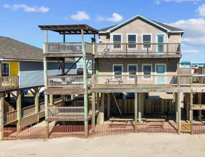 a large house with decks on the beach at Paradise Point - Barefoot Beachfront Living in Surfside Beach