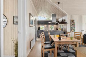 a dining room and kitchen with a table and chairs at FY100-Asperup-Bogevangsvej-4 in Asperup