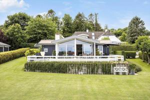 a house with a large white deck on a lawn at FY100-Asperup-Bogevangsvej-4 in Asperup