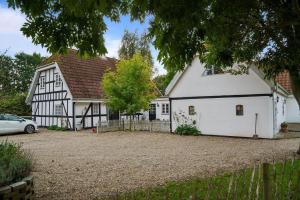 a white and black house with a car parked in front at FY283-Broby-Sandholtvej-45 in Brolo