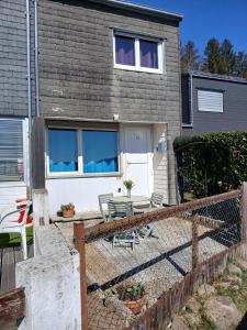 a house with two chairs and a fence at Maison 2-4 personnes, vue sur le Sancy in Murat-le-Quaire