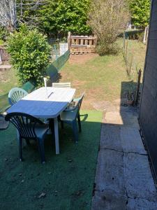 a blue picnic table and chairs on a lawn at Maison 2-4 personnes, vue sur le Sancy in Murat-le-Quaire +3 photos