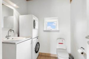 a small white bathroom with a toilet and a sink at FY295-Faaborg-Mosegarden-39 in Faaborg +17 photos